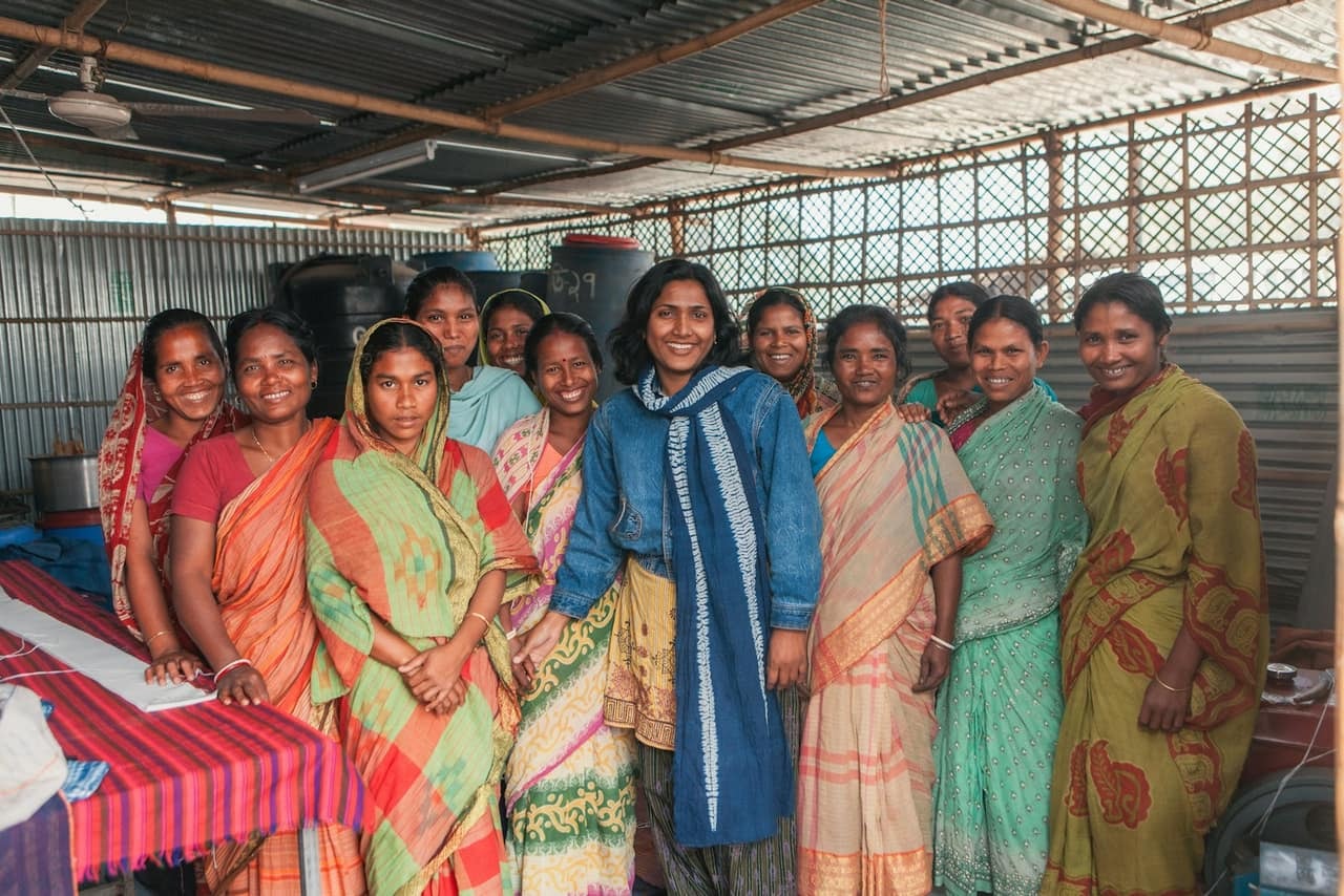 Women in colourful sarees at a self-help group meeting